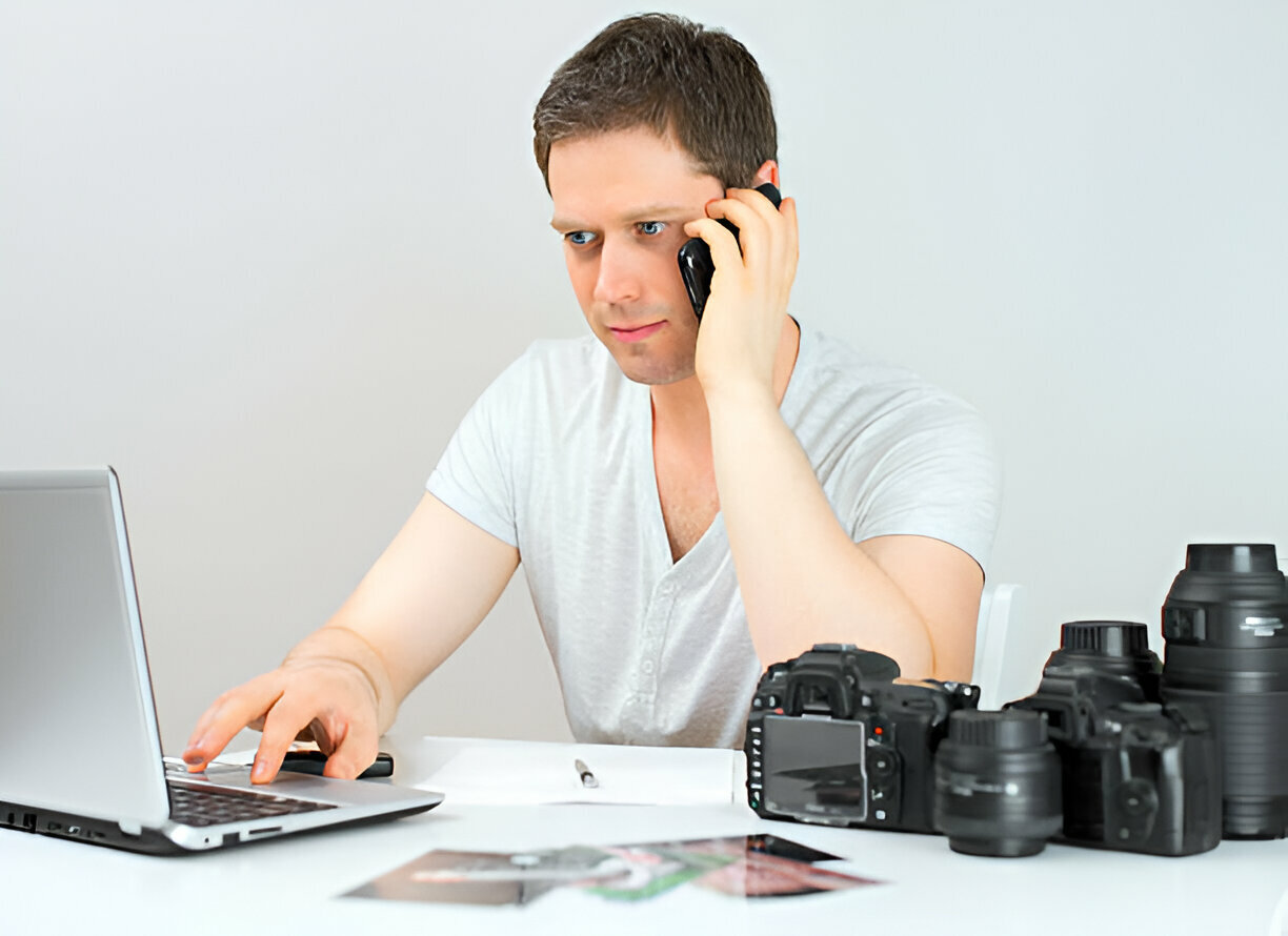 Photographer discussing photos with client by mobile phone. 